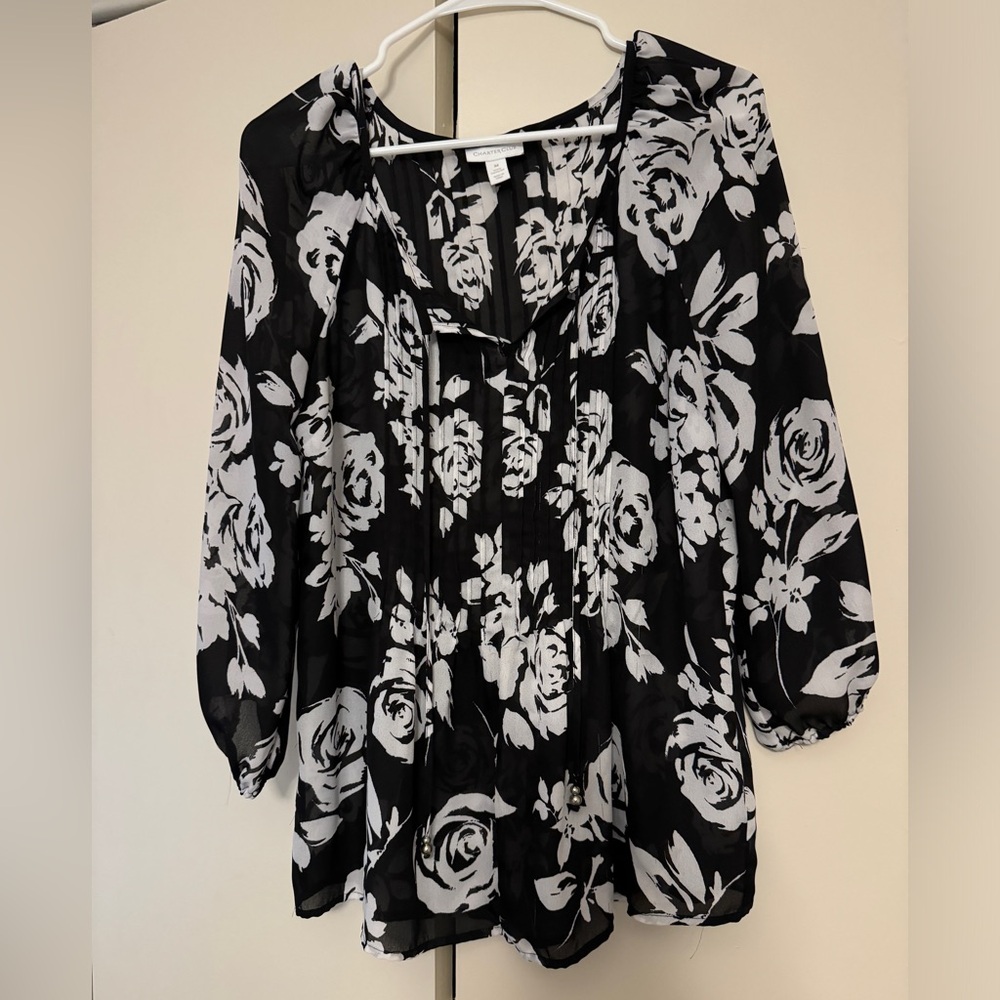 White floral print on black blouse. Seamed detail top front